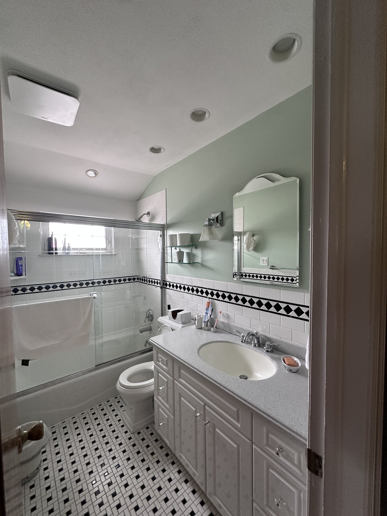 Completed bathroom with freshly painted green walls and crisp white trim